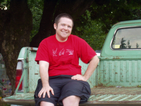 Austin smiling, sitting on a truck ‘Austin Unbound’